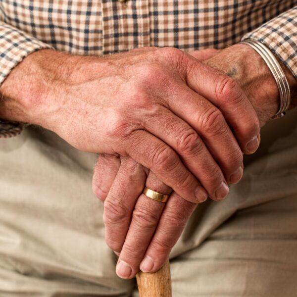 Elderly man leaning on a walking stick