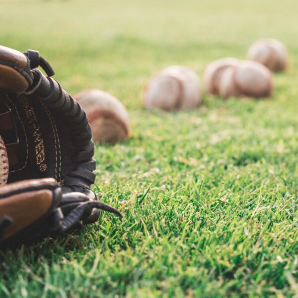 Baseball mitt and balls on a grass field