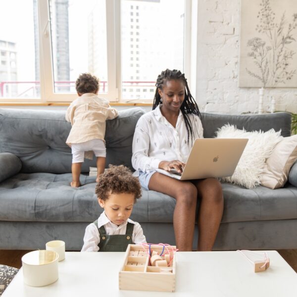Mother doing remote work while her two young children play
