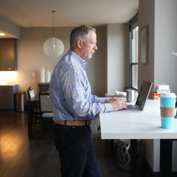 Older man using a laptop at a standing desk